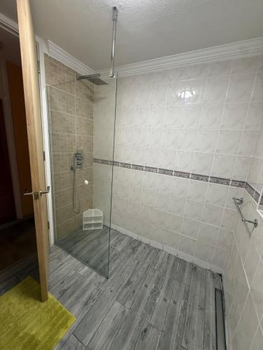 a bathroom with a shower with a glass door at A lovely bungalow with 3 bedrooms and nice garden in Boultham