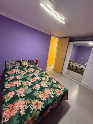 a bedroom with a bed with a green floral bedspread at A lovely bungalow with 3 bedrooms and nice garden in Boultham