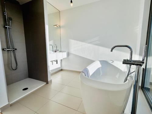 Un baño blanco con bañera y ducha. en Luxury Stylish Penthouse with Free Parking, en Viena