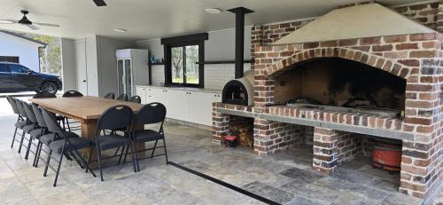 a kitchen with a brick fireplace with a table and chairs at Hideaway In Hartley in Hartley