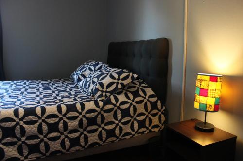 una cama en una habitación con una lámpara y una cama sidx sidx sidx en Departamento Cerca Movistar Arena, en Santiago