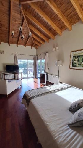 a bedroom with a large bed and a large window at Casa de Campo Petit Lodge in Estancia Grande