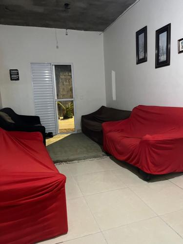 two beds in a room with red sheets at Mares in Mairiporã