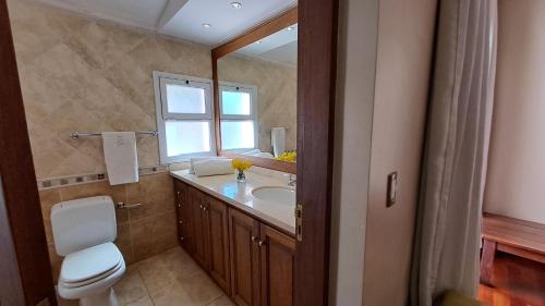 a bathroom with a toilet and a sink and a window at Casa de Campo Petit Lodge in Estancia Grande