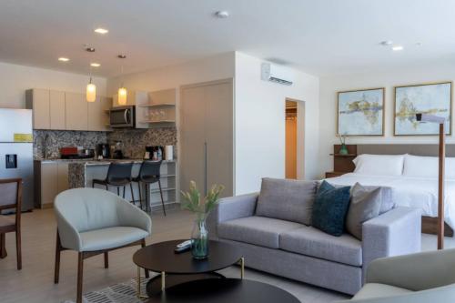 a living room with a couch and a bed and a kitchen at Bright & Airy Ocean View Studio in Costa del Este in Panama City