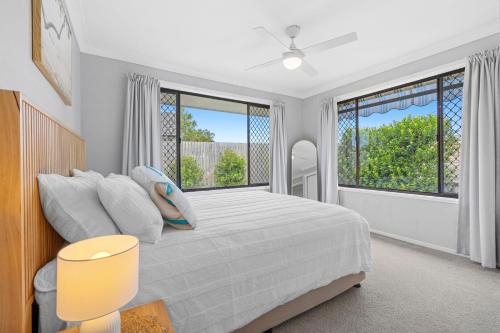 a bedroom with a bed and a large window at Marlin Manor Pet Friendly Home 600m to Beach in Chinderah