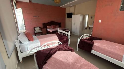 una habitación con tres camas en una habitación en CHAKIÑAN Hospedaje y Eventos OFICIAL, en Tumbaco