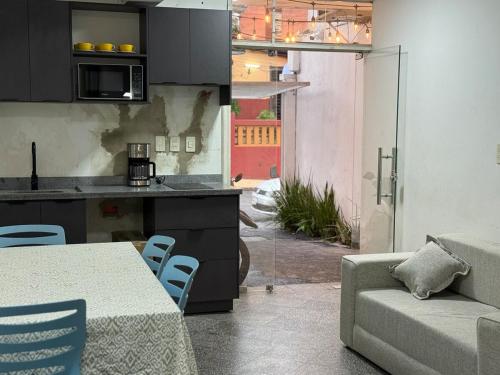 a kitchen and living room with a table and a couch at Alojamiento para 12 personas a pasos del Estadio Defensores del Chaco in Asuncion