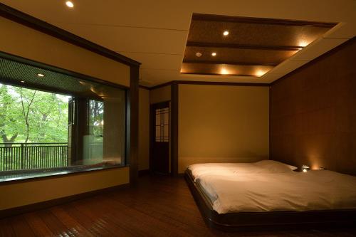 那須町にある那須高原の宿 山水閣のベッドと大きな窓のある寝室