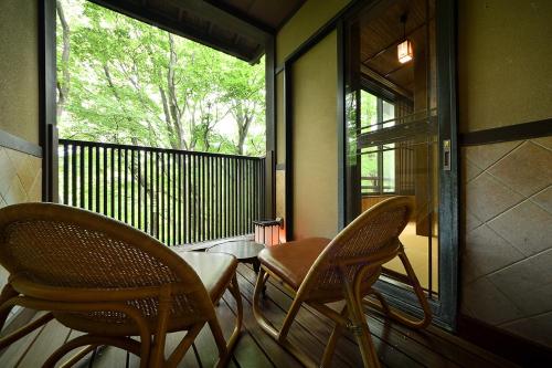 那須町にある那須高原の宿 山水閣の椅子2脚、窓のあるポーチ(テーブル付)