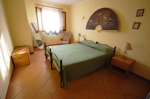 sypialnia z łóżkiem, stołem i oknem w obiekcie Villa Mediterraneo w mieście Chia