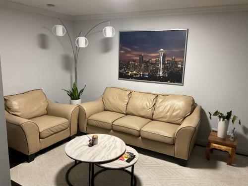 a living room with a couch and a table at Two fully independent unit - a modern house and a private apartment, each with its own entrance, located just 15 min from Sea-Tac Airport and 5 min from Des Moines Marina in Des Moines