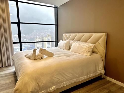 a bedroom with a large bed with a large window at Apartaestudio Centro Internacional UTEK in Bogotá
