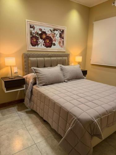 a bedroom with a large bed with two lamps at Modern apartment in Azul, comfort and style with patio in Azul