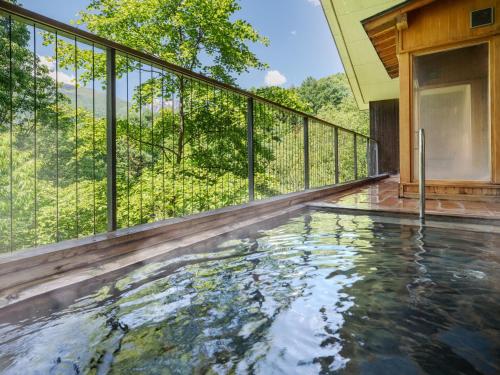 a swimming pool on the deck of a house at AZUMINO KOGEN Resort in Azumino
