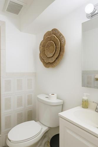 a white bathroom with a toilet and a sink at Pacifica Fort Lauderdale Airport in Dania Beach