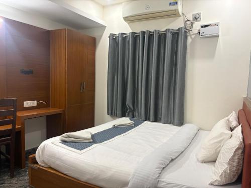 ein Schlafzimmer mit einem Bett mit einem grauen Vorhang in der Unterkunft Royal Elite Perumbakkam in Chennai