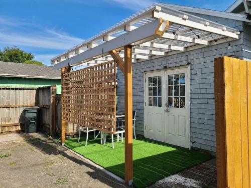 une pergola sur une maison avec une pelouse dans l'établissement Saltline Studio, à Tillamook