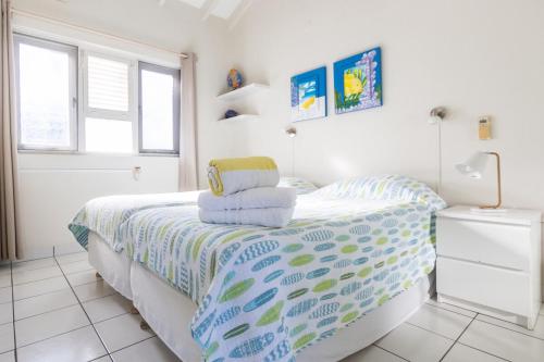 a white bedroom with a bed with towels on it at Aqualife Best view apartment in Willemstad