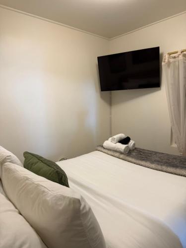 a white bed with a flat screen tv on a wall at Authentic Spacious 1BDR In Downtown Montreal in Montréal