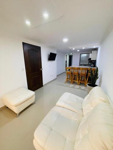 a living room with a white couch and a table at Acogedora casa en el carmen de Viboral in Carmen de Viboral