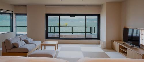 a living room with a couch and a tv at Suhaku in Suwa
