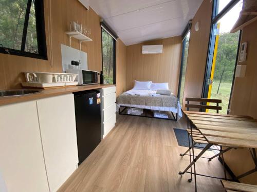 une chambre avec une cuisine et un lit dans une maison dans l'établissement Wombat Hideaway by Tiny Away, à Laguna
