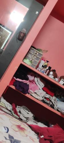 SimiligurhaSusiladevi guest house的一间卧室，里面有一张双层床，床边有粉色的架子。