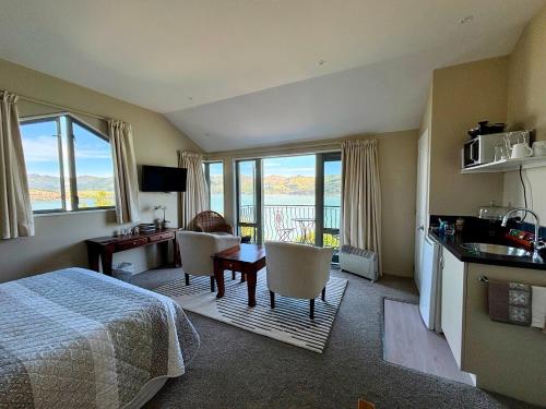 a hotel room with a bed and a table and chairs at Diamond Harbour Lodge in  Lyttelton