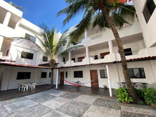 a building with a courtyard with a palm tree at Costa Ayala - Bungalow 1 with 2 dbl beds and 2 sofas in Los Ayala