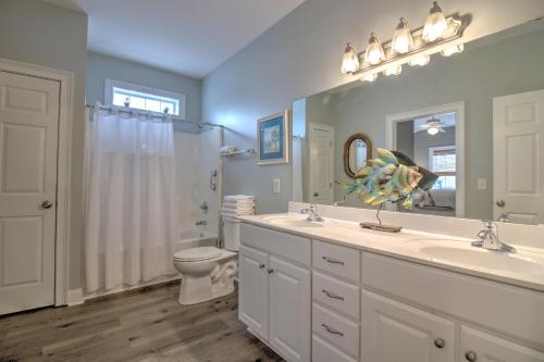 a bathroom with a sink and a toilet and a mirror at Stairway to Havens - North in Myrtle Beach
