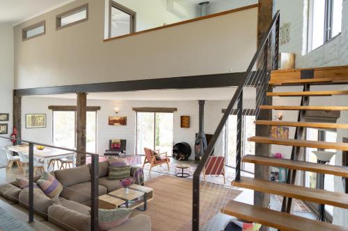 a living room with a staircase in a house at Lithia Guest House - Daylesford Region in Hepburn Springs