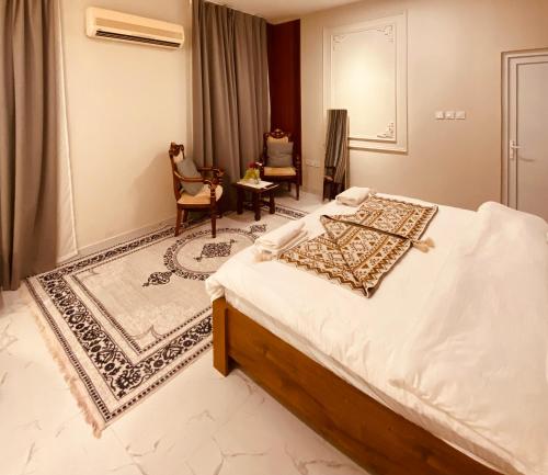 Un dormitorio con una cama, una silla y una mesa. en Jasmine Corner Chalet, en Mawāliḩ