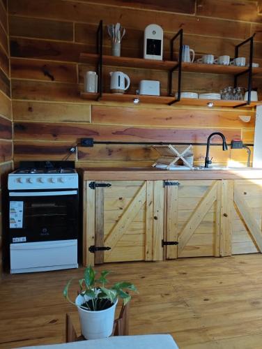 eine Küche mit Holzschränken und einem Herd mit Backofen in der Unterkunft Casas de Mar Cielo Azul in Badeort Reta