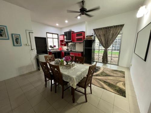 a kitchen and dining room with a table and chairs at Homestay Anjung Desa in Kuantan