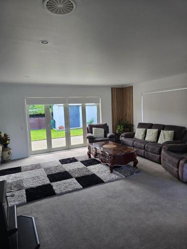 a living room with a couch and a table at Enjoy 4br home with lots of comfort & convenience in Taupo