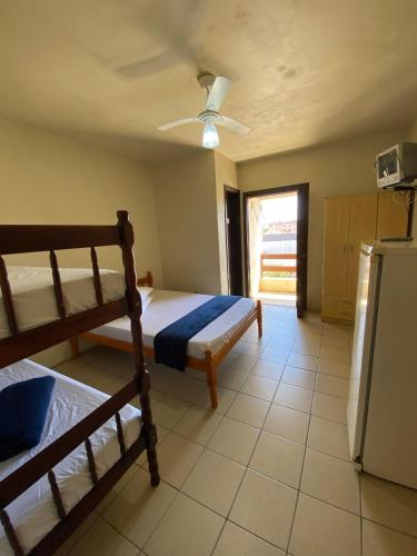 a bedroom with two bunk beds and a refrigerator at Pousada Nova in Tramandaí