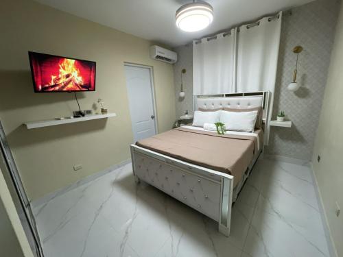 a bedroom with a bed with a tv on the wall at Apartamento cerca del aeropuerto en los frailes in Los Frailes