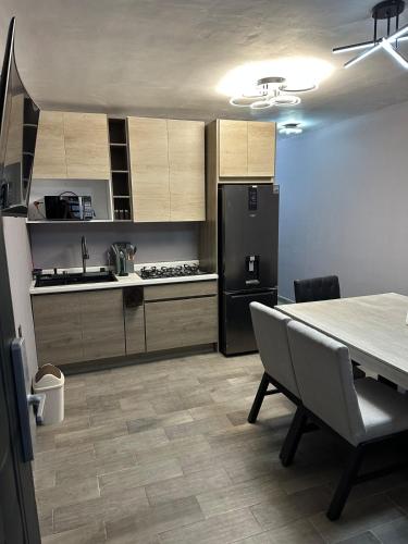a kitchen with a table and a black refrigerator at Depa nuevo y equipado en Saltillo 2 recámaras in Saltillo