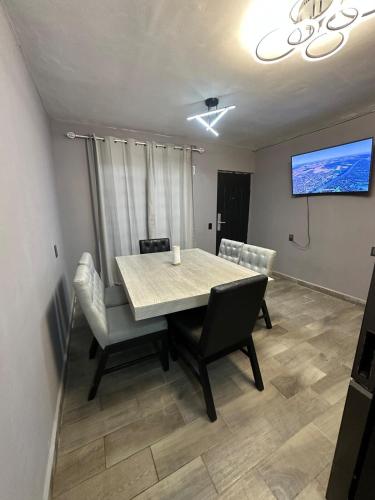 a dining room with a table and chairs and a tv at Depa nuevo y equipado en Saltillo 2 recámaras in Saltillo