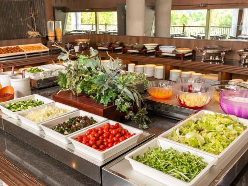 a buffet line with vegetables in white dishes at Izumigo AMBIENT Azumino Hotel in Azumino