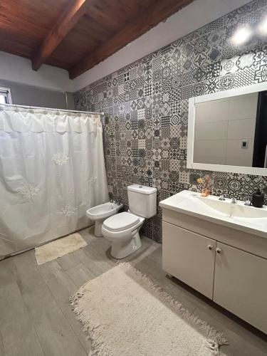 a bathroom with a toilet and a sink and a mirror at La moradaa in Federación