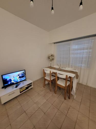 ein Wohnzimmer mit Tisch und Fernseher in der Unterkunft FLAT Fleming Martinez in Martínez