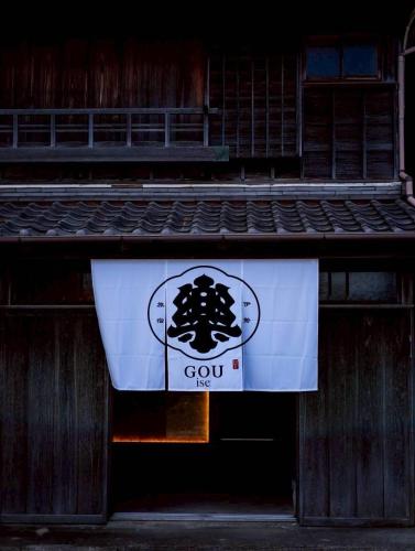 a sign on a building with a logo on it at 樂 Gou in Ise