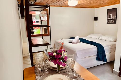 a bedroom with a bed and a table with flowers on it at Chalés Duquesa do Vale in Campos do Jordão