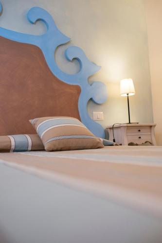 a bedroom with a large bed with a wooden headboard at Hotel Baglio Catalano in Custonaci