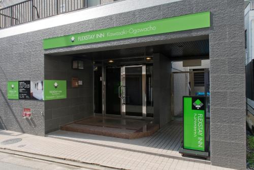 a entrance to a building with a green sign on it at FLEXSTAY INN Kawasaki Ogawacho in Kawasaki