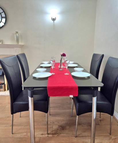 a dining room table with a red napkin on it at Crescent House - 3 Bedrooms, 2 bathrooms, large lounge, sunny conservatory, full kitchen, parking for 2 cars in Buckinghamshire