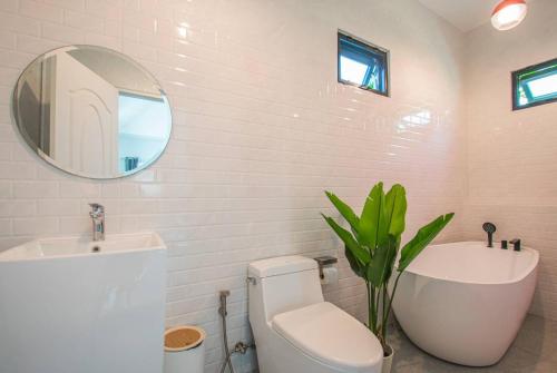 a bathroom with a toilet and a sink and a mirror at Lamoon Village Khaoyai บ้านละมุน เขาใหญ่ in Pak Chong
