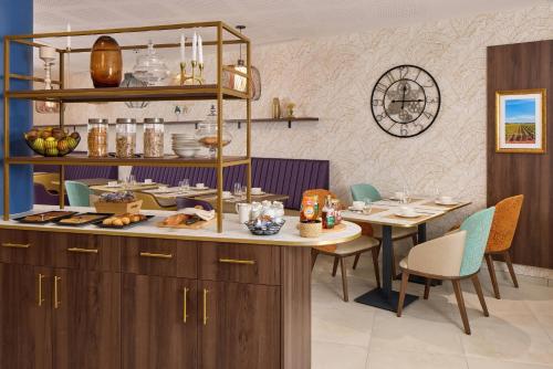 uma sala de jantar com uma mesa e um balcão com comida em Zenitude Quality Aparthotel Bordeaux Saint-Jean em Bordéus